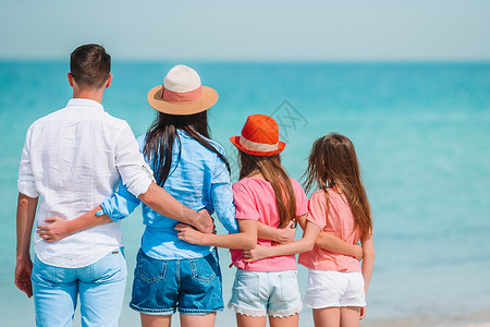 海滩家庭度假的年轻家庭玩得很开心父亲女孩海岸海岸线喜悦支撑幸福假期太阳成人背景