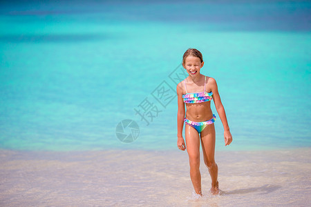 送水女孩儿暑假在沙滩上可爱的小女孩儿情调情感热带乐趣快乐孩子海滩海景运动蓝色背景