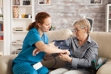 使用数字血压装置的女护理员成人卫生女士护理病人保健老年女性药品测量背景