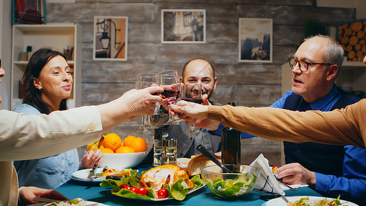 晚上家人聚在一起吃晚饭食物玻璃桌子团圆祖母快乐女士男人祖父房子背景图片