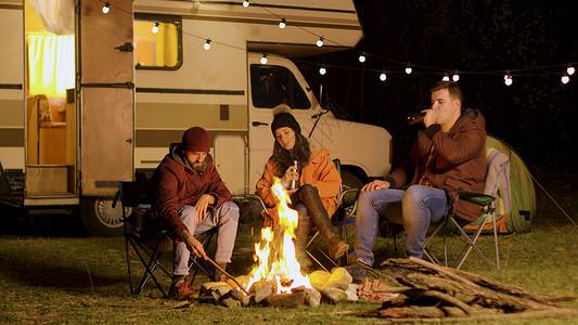 一群朋友享受着在火前静静的瞬间团体营火火焰火树林森林星星时间帐篷乐趣胡子背景图片