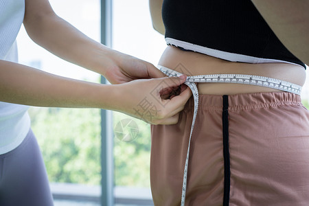 厚度测量年轻女训练员 测量体重超重妇女体力脂肪层测试培训师肌肉腰围皮肤腹部身体卫生饮食肥胖背景