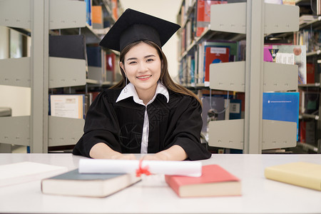 持有毕业证书的快乐研究生手头有文凭 教育学士学位女性幸福大学成就帽子微笑女士学习学校背景高清图片素材