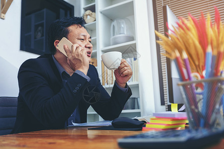 忙趁东风放纸鸢身穿西装的商务人士在电话上聊天 在电脑上工作 忙e技术商务咨询互联网文档经理谈判网络套装交易背景