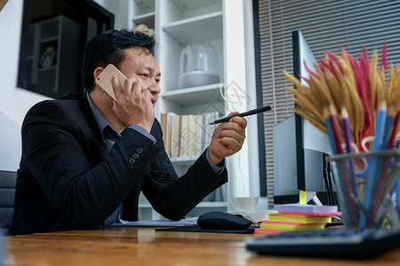 忙趁东风放纸鸢身穿西装的商务人士在电话上聊天 在电脑上工作 忙e商务成功人士合伙细胞网络市场经理互联网咨询背景