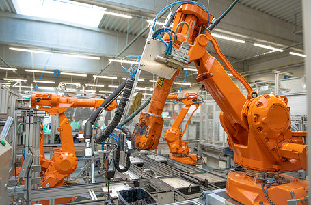 工厂物联网生产线上的橙色机械臂 由具有人工智能的计算机控制背景