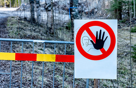 冲入禁区警告标志的特写照片-禁止进入禁区 标志挂在金属栅栏上 背景是森林 施工现场人身安全禁区 禁区 大风险区背景