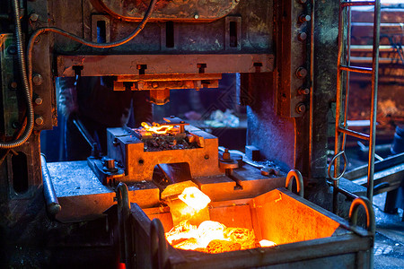 热成型关于在肮脏的黑暗工厂中形成压力后新制制成的热钢工作机件的近视图片生产炼铁温度金属力量铁匠矿渣火花工件蒸汽背景