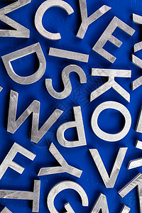 蓝色背景上银色金属英文字母字符的抽象平坦背景字体学校写作知识学习语言英语语法教育白色背景