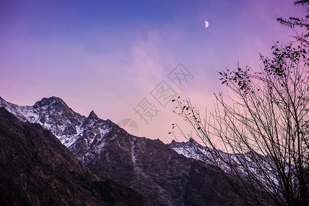 天色暗 月亮在卡拉科拉姆山脉的雪顶上升起背景图片