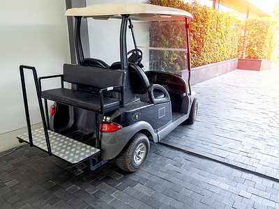 黑高尔夫车或者酒店里的高尔夫球车石头车轮驾驶顾客娱乐假期机器奢华行李地面背景图片