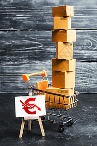 箱子标志装满箱子和带有欧元符号向下箭头的标志的购物车 货物销售和零售收入减少 购买力下降 降价 打折背景