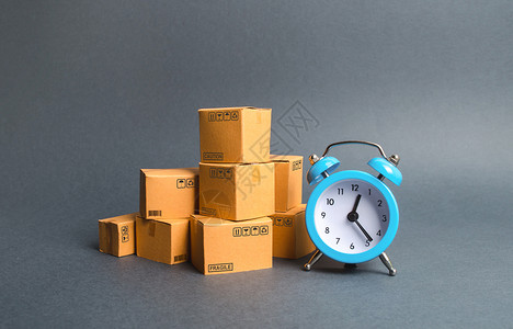 盒子链素材一堆纸板箱和一个蓝色闹钟 快递概念 临时存储 限时优惠和折扣 优化物流配送 提高效率 降低成本背景