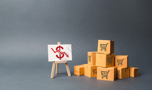一个箭头素材一堆纸箱和一个红色向下箭头的支架 商品和产品生产下降 经济低迷和衰退 消费需求下降 价格下跌 利润下降背景