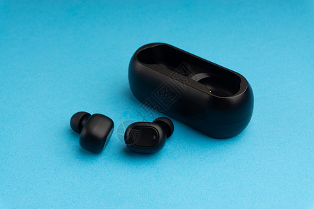 耳机耳塞设计蓝色背景上的无线耳塞或耳机黑色助听器商业工具白色信号充电技术旅行娱乐背景