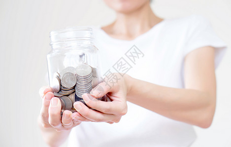 呃女人拿着钱罐子 硬币紧闭货币贷款金属银行储蓄女士女性银行业投资保险背景