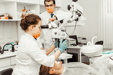 牙科技师精致两个牙医治疗一个病人 牙医的专业制服和设备 医疗保健装备医生工作场所 牙科衰变牙齿女士口腔科微笑口服治愈医院程序牙科技师背景