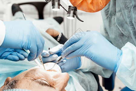 手术时坐在牙医椅上的病人 拔牙 植牙 牙医的专业制服和设备 医疗保健装备医生工作场所 牙科牙科技师医院程序药品访问诊所牙齿镜子卫背景图片