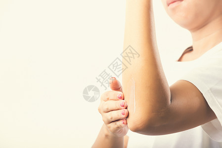 手肘疼女孩女人在手肘上涂润肤霜身体化妆品奶油温泉成人护理手指卫生手臂推杆背景