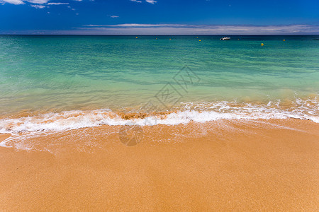 浅蓝色海浪波纹沙沙热带海滩上浅蓝色海洋的软波浪海岸线海岸海景明信片天空假期天堂支撑蓝色阳光背景