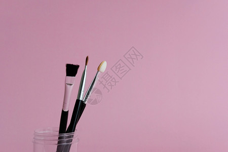 惠战到底化妆品宣传单带粉色柔和背景的瓶子上的一套化妆刷工具背景