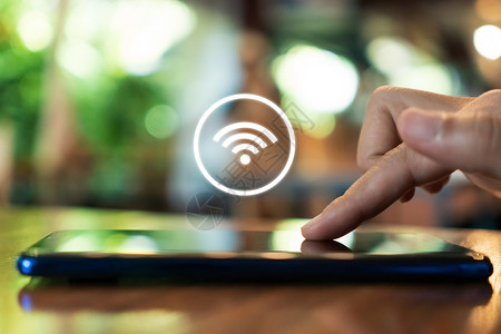 wifi图在咖啡馆背景中使用带 wifi 图标的智能手机的女性手信号安全热点建筑网络白色人士互联网通讯机动性背景