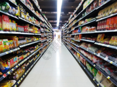 超市货架物品抽象模糊的超市过道 货架上有五颜六色的商品 背景模糊的顾客在收银台背景