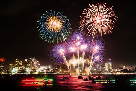 国庆日喜庆的五颜六色的烟花在夜景中照亮了城市上空 为节日和庆典背景烟火假期天空嘉年华墙纸派对新年焰火展示念日背景