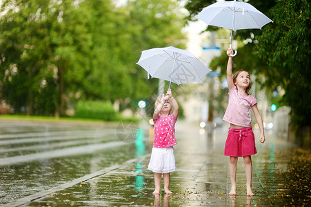 两个可爱的小妹妹 在雨下玩得开心女性舞蹈团队姐姐快乐自由人行道兄弟水滴乐趣图片