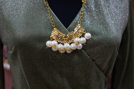 绿色装饰服装 金首饰和珠珠 零售背景图片