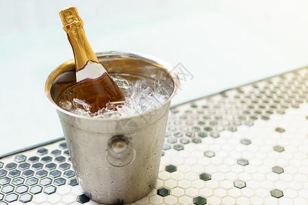 香槟冷却器冰桶香槟瓶和泡泡池附近的两个杯子冷却器瓶子奢华庆典周年纪念日泡酒游泳夫妻蜜月背景