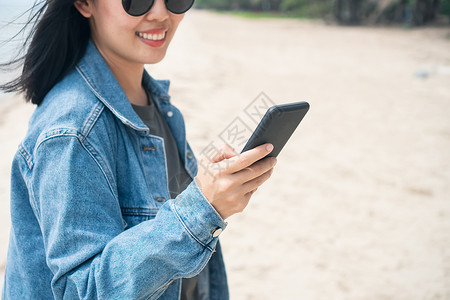 墨镜手机端模板女性使用智能手机从事商业 社交网络 与海滩室外空间的通信工作互联网工具展示桌子用户阅读软垫旅行技术消息背景