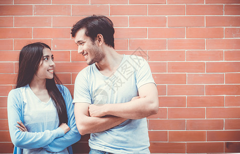 年轻一对像亚洲人一样有魅力的年轻夫妇成人倾斜手臂衣服女性场景女士喜悦男人男性背景图片