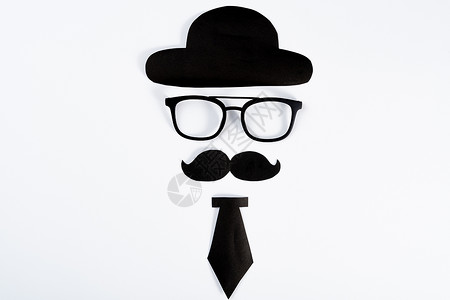 父亲节帽子眼镜快乐父亲节背景概念与剪纸的帽子 眼镜 黑色胡子和白色背景上的领带 带有文本复制空间背景