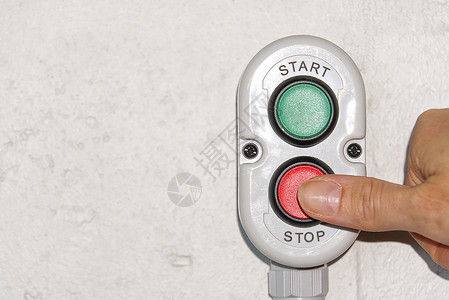 停止按钮手指按着停产按钮进行生产背景