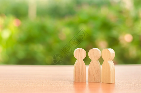 义工三个木制人物站在大自然的背景上 交流 聚会场所 进行对话 案例和计划 社会和社区的讨论 放置文本背景