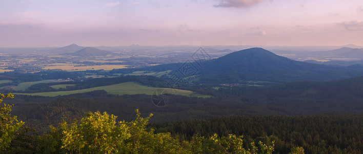 瓦尔德Lusatian 山脉 宽全景 从捷克与德国边境的 Hochwald Hvozd 山全景 蓝绿色的山林和粉红色的多云日落天空背景背景