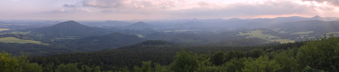 塞雷萨斯Lusatian 山脉 宽全景 从捷克与德国边境的 Hochwald Hvozd 山全景 蓝绿色的山林和粉红色的多云日落天空背景背景