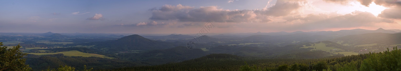 苏台德Lusatian 山脉 宽全景 从捷克与德国边境的 Hochwald Hvozd 山全景 蓝绿色的山林和粉红色的多云日落天空背景背景
