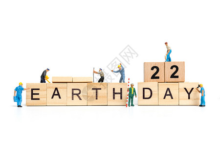 数字9字样微型人 工人团队在木制背景的木块上建造地球日字样 地球日概念回收生物世界数字男性生态工作海报环境行星背景