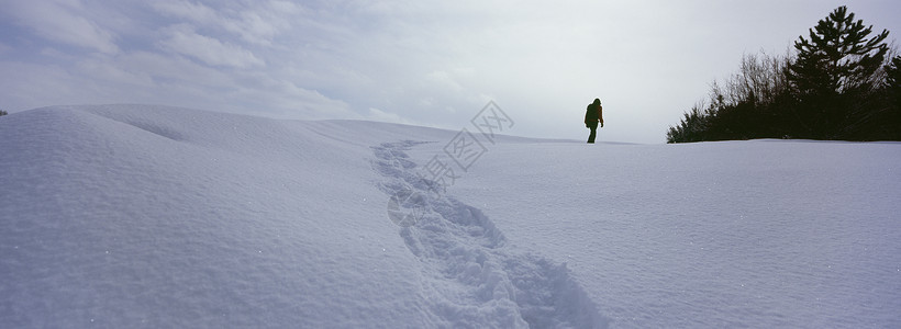 在雪地上行走的人 留下足迹的痕迹在一片土地上天气脚印天空地平线孤独踪迹全景天气状况白色自然背景图片