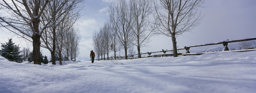 在雪覆盖的土地上行走的人白色自然天气天空天气状况全景栅栏背景图片