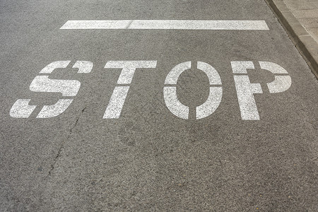 沥青路口的沥青路标有“STOP”标记高清图片