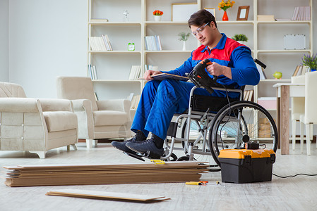 工作不平等残疾人在办公室铺地板层的男子房子承包商作坊工作钻头木匠修理工压板修理椅子背景