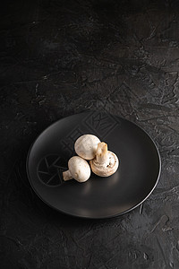 三个冠尼翁蘑菇 在黑盘上吃健康食物 深底黑盘盘子团体厨房营养美食饮食烹饪背景