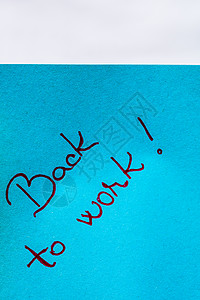 回到工作时的笔迹文字在蓝纸上特写邮政公告记忆商业备忘录日程短信说明笔记贴纸背景图片