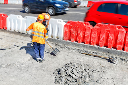 混凝土路公路工人在修路期间击倒旧的混凝土 铲平一个工作区背景