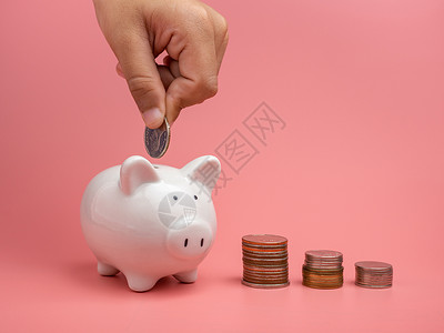 白猪银行 硬币和人手 把硬币放进小猪 b成人身体退休金钱粉色货币银行业存钱罐帐户人体背景