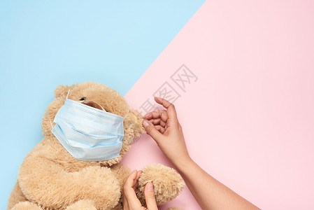 偎穿戴医疗面具的泰迪人 蓝粉色背景 概念o背景