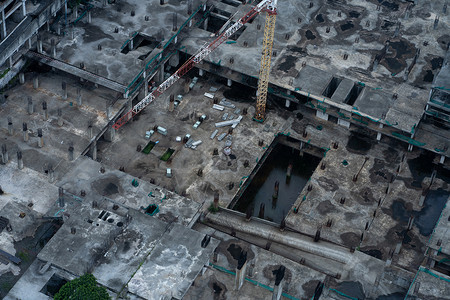 未竣工楼层雨后大型建筑物的建筑工地的最顶端 管道被开进 下面的楼层被建造材料天空项目脚手架建设者工作职场公寓商业机器背景